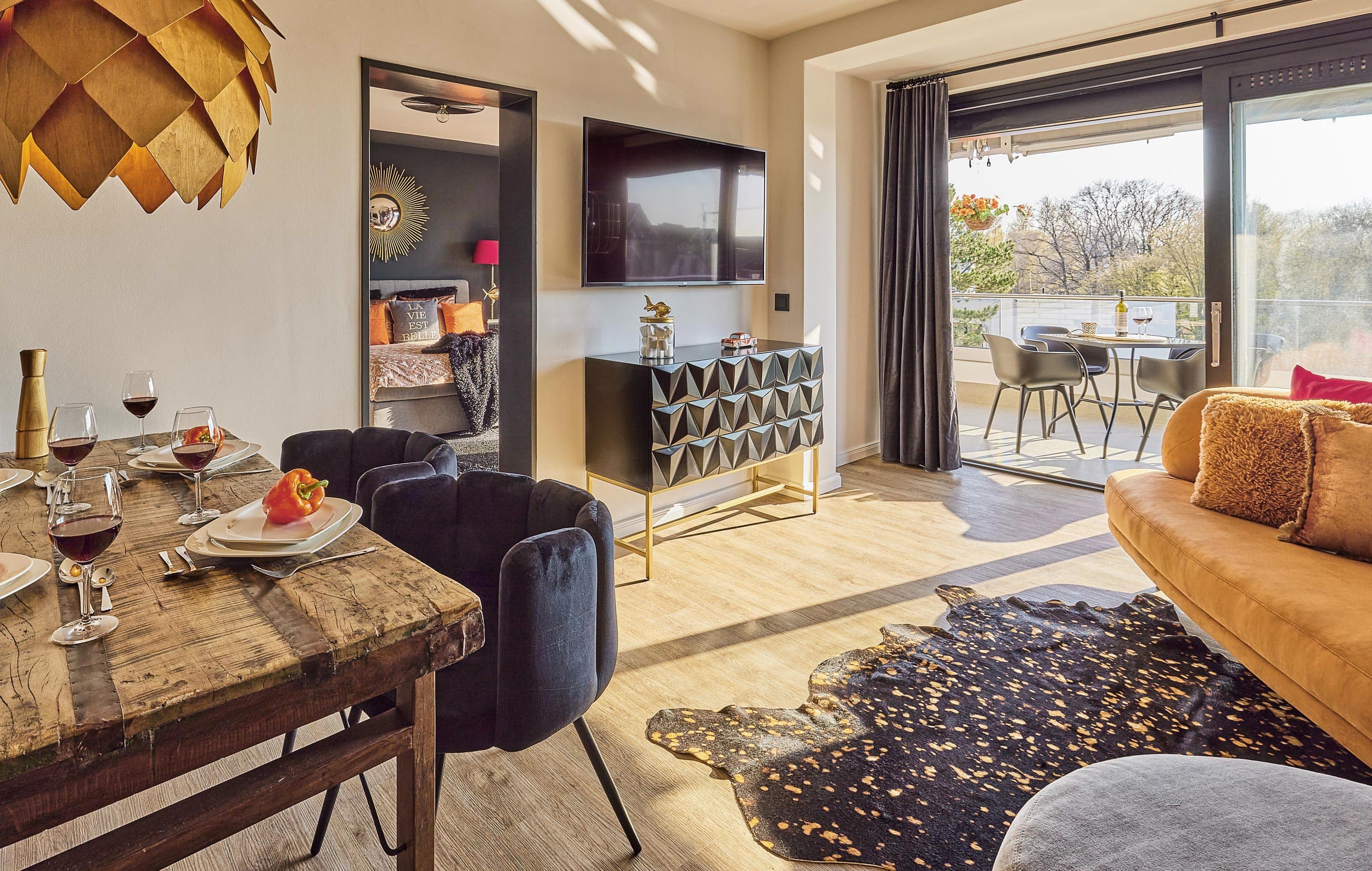 I-LOVE-HOME-Ferienwohnung-Essen_RET Essbereich mit Blick auf das Bett und die großzügige Terrasse in der Ferienwohnung Scharbeutz an der Ostsee